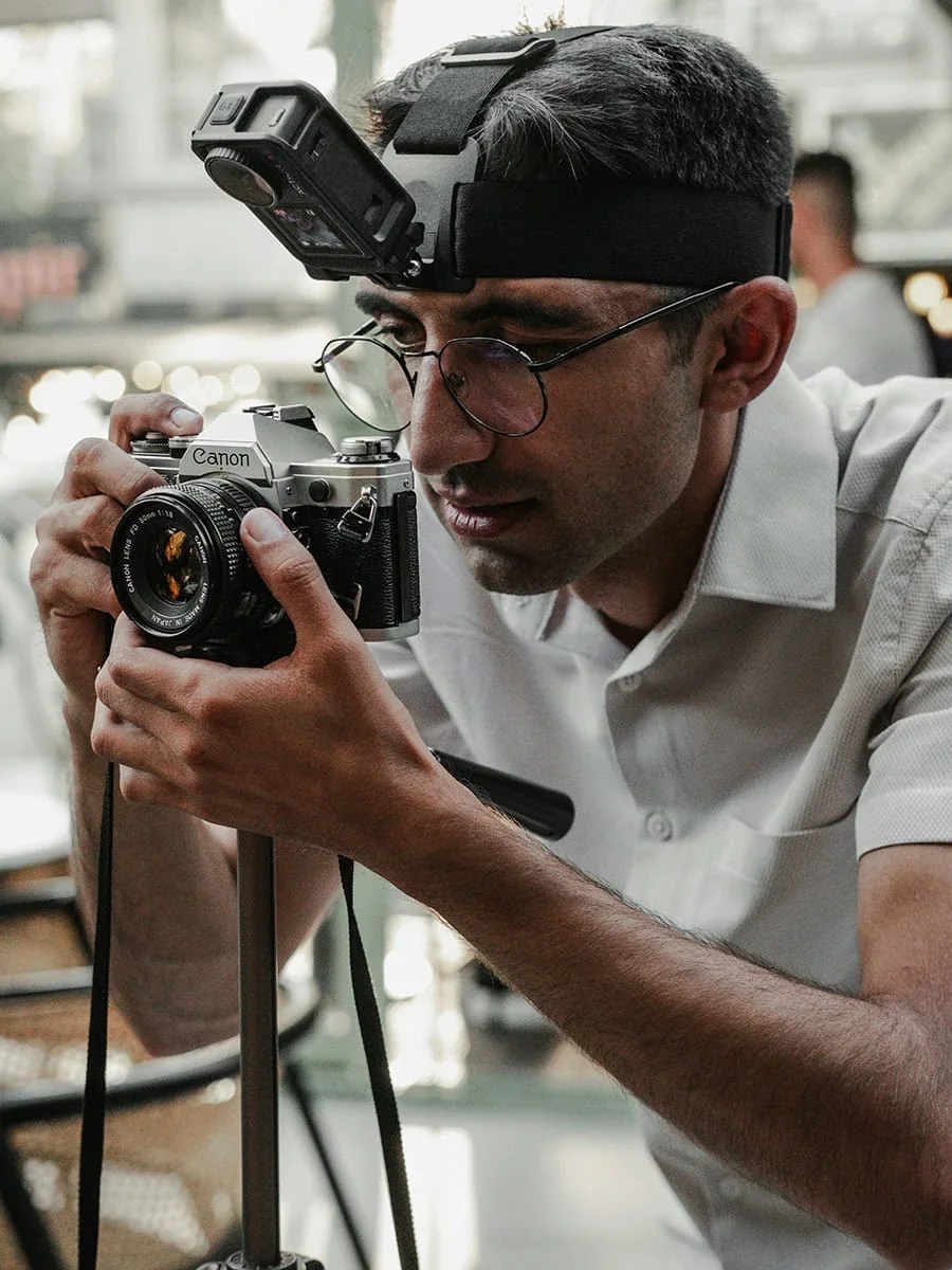Fotógrafo profesional utilizando cámara Canon con visor y Head Mount para captura de imágenes en eventos y producciones audiovisuales en Soluciones AIT.