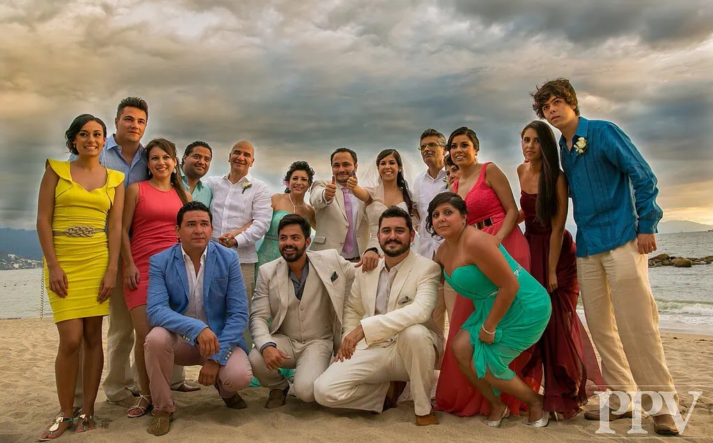 Grupo de personas en la playa celebrando juntos, ambiente festivo y de amistad en un escenario costero, perfecto para eventos y reuniones familiares.